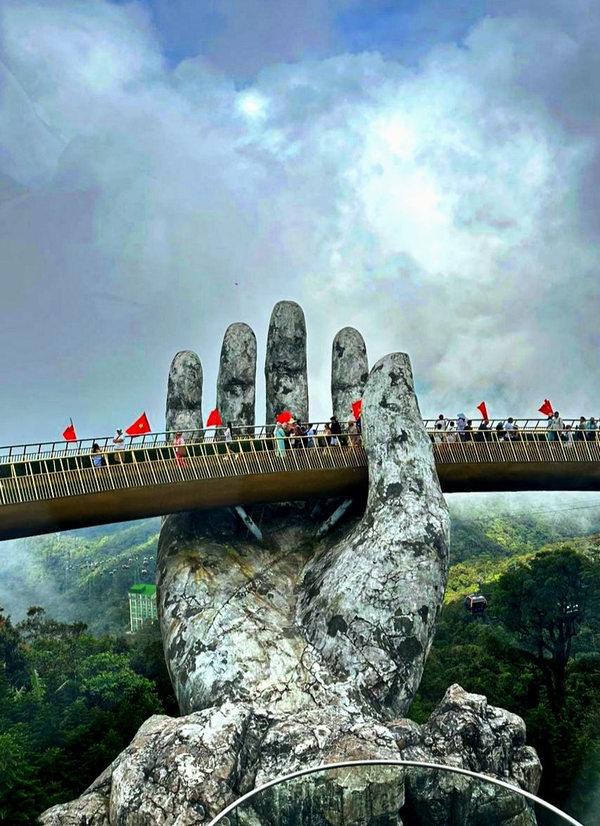 Giant stone hands cradle the Golden Bridge walkway at Ba Na Hills, high above the Da Nang valley