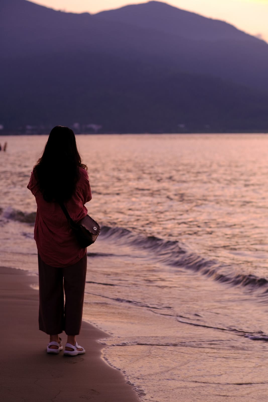Sunrise on My Khe Beach, a fishing boat on the wet sand and the sun low over the East Sea