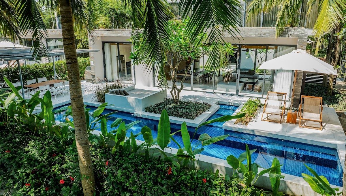 Private pool villa at Naman Retreat on Non Nuoc beach in Da Nang, surrounded by palm trees and tropical gardens with a sun lounger and umbrella