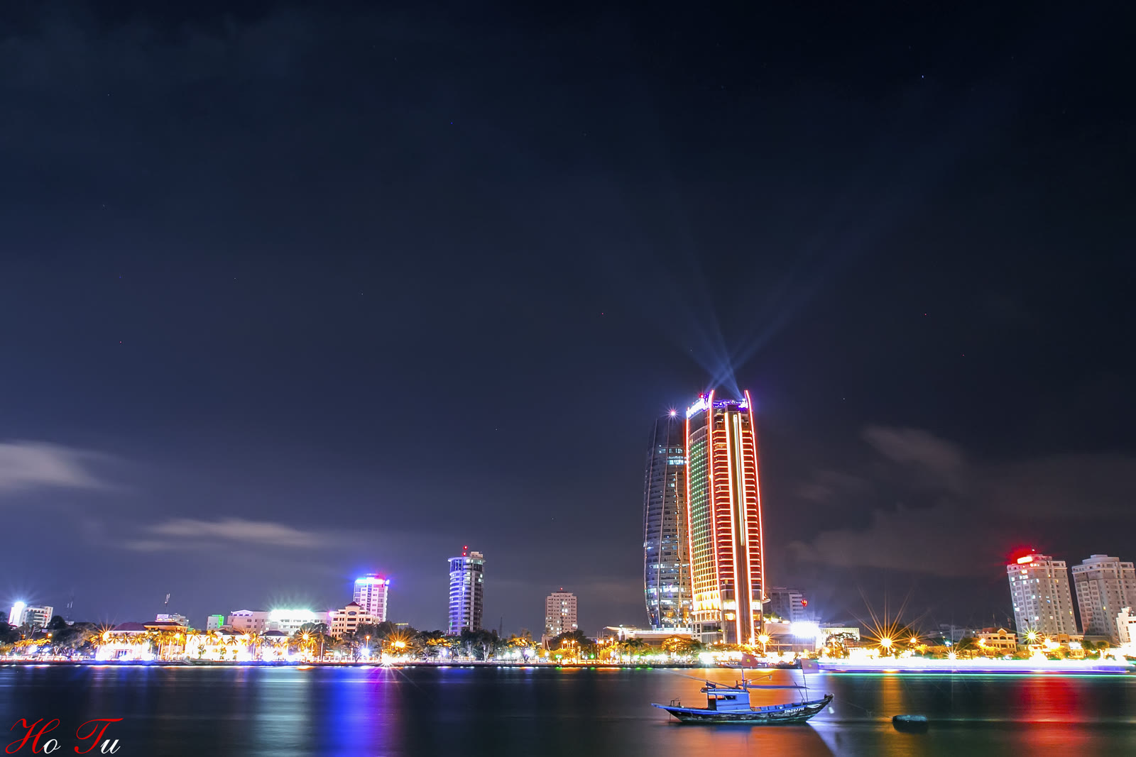 Novotel Danang Premier Han River at night, the tower lit beside the Han River