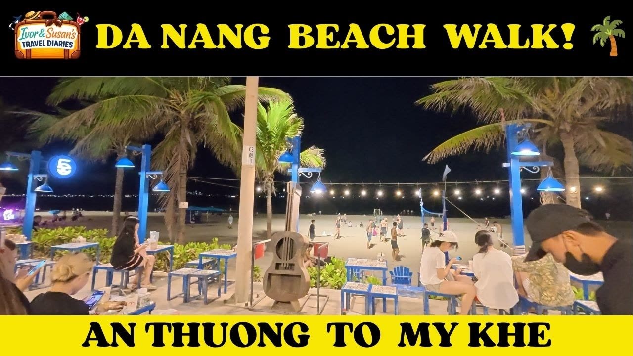 My Khe Beach at night, wet sand in the foreground and the Da Nang hotel skyline lit behind it